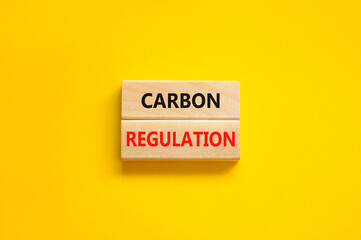 Wall Mural - Carbon regulation symbol. Concept words Carbon regulation on wooden blocks on a beautiful yellow table yellow background. Business and carbon regulation concept, copy space.