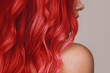 © Марина Демешко - Close-up of the wavy hot red hair of a young woman isolated on a beige background. Result of coloring, highlighting, perming. Beauty and fashion