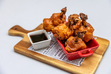 Poster - A closeup shot of roasted chicken portion and a sauce on a wooden board