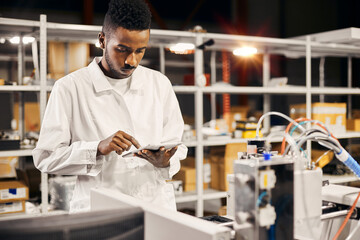 Wall Mural - african engineer programming equipment with tablet at factory