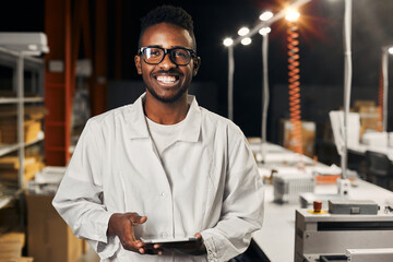 Wall Mural - smiling african engineer working with tablet at factory