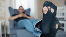 Man With Holey Socks At Home