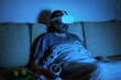 © scaliger - Man using virtual reality headset watches TV or movie in dark