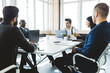 © xartproduction - Group of young business people working and communicating while sitting at the office desk together with colleagues sitting. business meeting