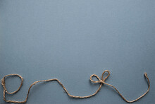 Blue Background With A Rope Along The Contour With A Bow.  Minimalistic Postcard