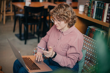 Young caucasian woman working via laptop at the cafeteria