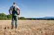 © BIB-Bilder - After the harvest, a farmer stands on his mown grain field and enjoys the view over the vast country to the foothills of the Swabian Alb.