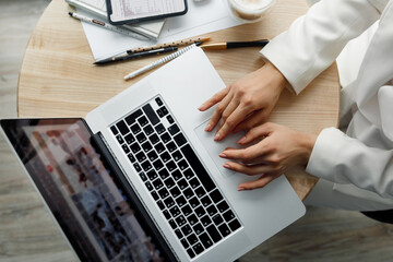 Closeup of a female hands busy typing on a laptop. Woman working at laptop computer hands close up.