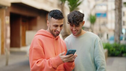 Wall Mural - Young hispanic couple smiling confident making selfie by the smartphone at street