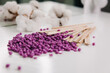 Close-up of purple wax granules scattered from a jar. Beauty procedure to remove unwanted hair from the body.