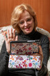 © Marco Taliani - A middle-aged blonde woman uses a tablet for a video call while sitting in an armchair