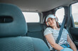 © phpetrunina14 - woman sitting at car rear sits listening music with headset