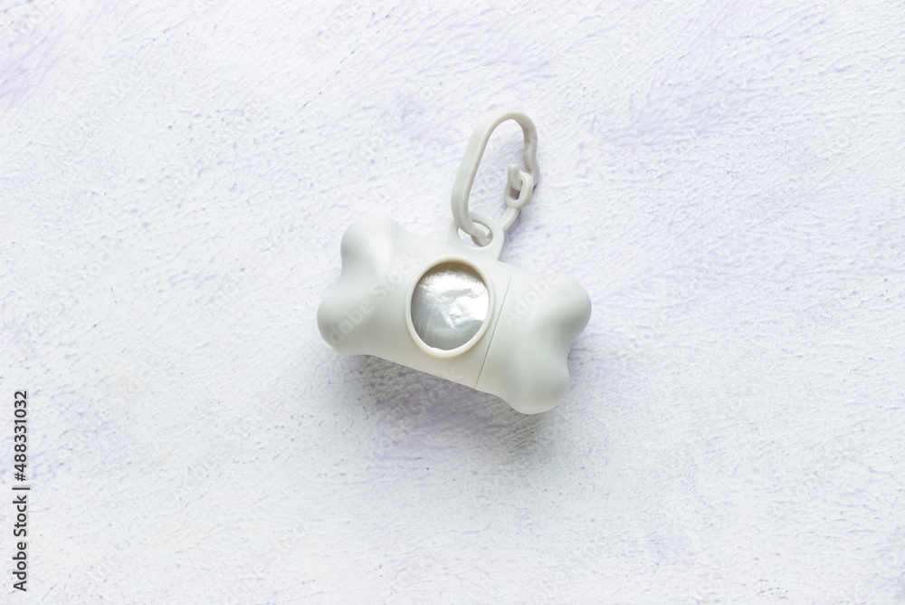 Dispenser with pet waste bags on light background