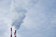© Oksana - Three pipes of a thermal power plant close-up. Smoke rises from the chimneys into the sky. Copy space .