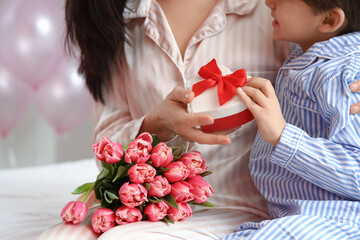 Poster - Little son greeting his mother for International Women's day in bedroom at home