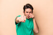 © Asier - Young caucasian man isolated on beige background throwing a punch, anger, fighting due to an argument, boxing.