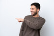 © luismolinero - Young Brazilian man isolated on white background pointing finger to the side and presenting a product