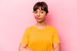 Young hispanic woman isolated on pink background suspicious, uncertain, examining you.