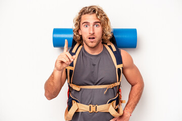 Wall Mural - Young mountaineer caucasian man with a big backpack isolated on white background having an idea, inspiration concept.