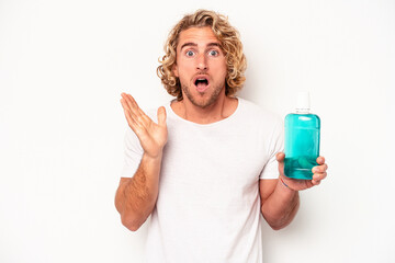 Wall Mural - Young caucasian man holding a clapperboard isolated on white background surprised and shocked.