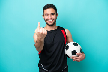 Wall Mural - Young football player Brazilian man isolated on blue background doing coming gesture