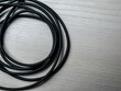 black braided data cable coiled on white desk
