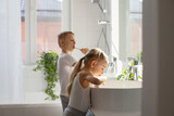 Fototapeta Tulipany - Children brother and sister wash and brush their teeth in the bathroom