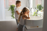 Fototapeta Tulipany - Children brother and sister wash and brush their teeth in the bathroom