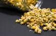 Jar with Chamomile on a black background, close up photo