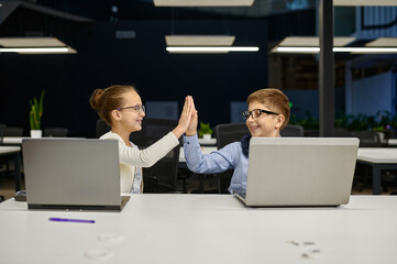 Cheerful successful children coworkers colleagues giving highfive