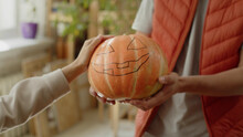 A Man Is Holding A Pumpkin In His Hands And A Lady Is Stroking It