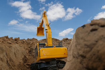 back view of excavator are digging the soil in the construction site on the sky background