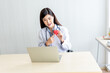 © Anatta_Tan - Asian attractive woman doctor Looking at and using a computer notebook To provide advice to heart disease patients By communication online, to health care and doctor online concept.