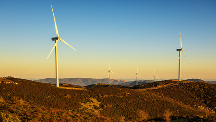 Wall Mural - wind turbines on a beautiful sunset sky in a mountain wind farm in sardinia. renewable energy concep
