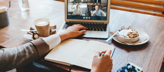 Wall Mural - Cafe workplace. Video call using laptop. Woman has remote team conference