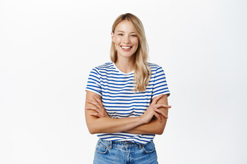 Wall Mural - Beautiful happy girl laughing and smiling. Modern scandinavian woman posing against white background, looking happy, wearing summer clothes