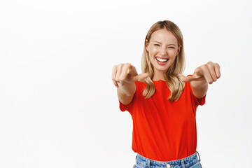 Wall Mural - Its you. Smiling blond girl pointing fingers at camera, its you, congrats gesture, congratulating, standing over white background