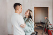 © Kseniia - Couple in unfinished building. Woman and men dreaming about apartment renovation. Young couple in new property. Family buy new flat. Strat a new life