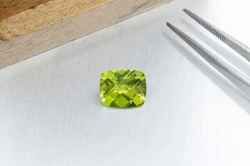 macro mineral faceted stone cut Peridot on a gray background