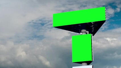 Wall Mural - two blank green billboards or large displays and moving white clouds against blue sky - timelapse. a