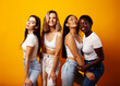 © iordani - diverse multi nation girls group, teenage friends company cheerful having fun, happy smiling, cute posing on yellow background, lifestyle people concept, african-american, asian and caucasian