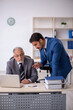 © Elnur - Old male boss and young male employee working in the office