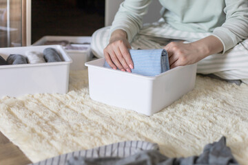 Wall Mural - Female hands organizing storage of underwear socks t shirts use Marie Kondo's method. Perfectionist