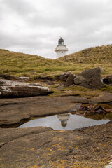 Wall Mural - lighthouse reflecting in a rock pool