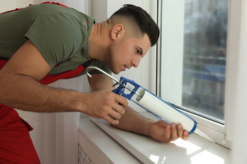 Sticker - Construction worker sealing window with caulk indoors