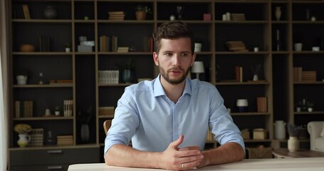 confident millennial man teacher sit by table lead virtual event webinar lecture on distance speak b