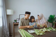© Odua Images - muslim asian family making ketupat for eid mubarak together