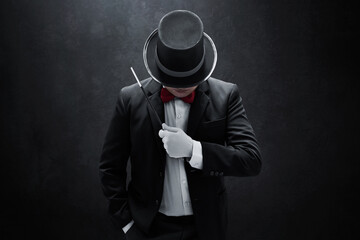 Magician holding magic wand on dark background