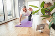 © Westend61 - Smiling senior man balancing on exercise mat doing workout at home