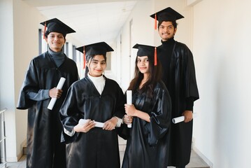 education, graduation and people concept - group of happy indian students